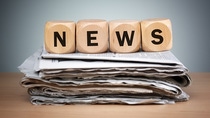Vier Würfel, die das Wort News bilden, liegen auf einem Stapel Zeitungen Vier Würfel, die das Wort News bilden, liegen auf einem Stapel Zeitungen