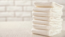 Seven folded diapers on a white table. Seven folded diapers on a white table.