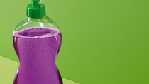 Bottle of dish washing soap on a green background. Bottle of dish washing soap on a green background.