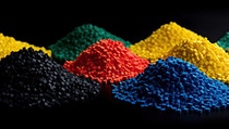 Small, colorful plastic pellets against a black background. Small, colorful plastic pellets against a black background.