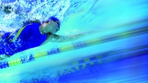 Women swimming in pool, underwater view (blurred motion)