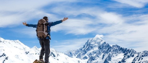 Hiker with arms spread wide on a mountain top