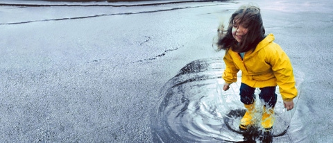 Girl (3-5) jumping in puddle wearing rain gear Girl (3-5) jumping in puddle wearing rain gear