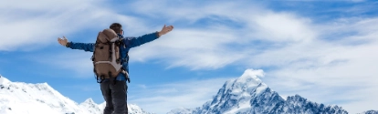 Hiker with arms spread wide on a mountain top