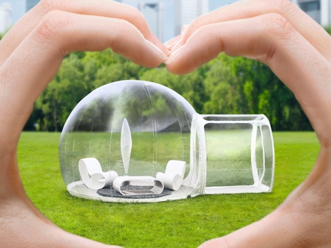 A plastic igloo on a green lawn.