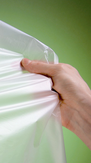 Hands pulling apart florescent plastic sheet 