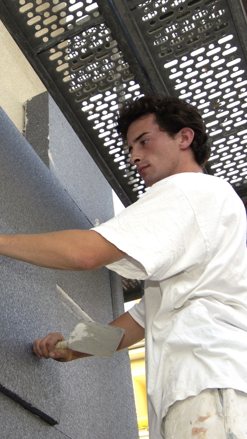 The Neopor® is applied to the façade. The craftsman presses firmly on the insulating panel to fix it in place. The insulating material is then doweled.