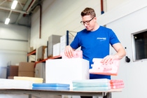 Ein Arbeiter füllt eine Kühlbox mit Kühlelementen (Copyright: Schaumaplast) Ein Arbeiter füllt eine Kühlbox mit Kühlelementen (Copyright: Schaumaplast)