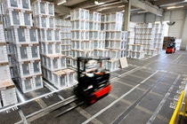 A forklift truck driving through a hall with stored dishwashers. A forklift truck driving through a hall with stored dishwashers.
