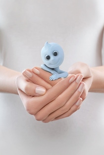 Dinchy, the brand ambassador for Hexamoll DINCH, smiling, being cradled by a womens hands.