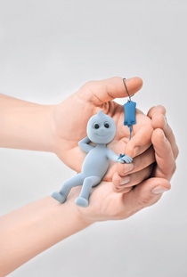 Dinchy, the brand ambassador for Hexamoll DINCH, laying in a hand and reiceiving an infusion